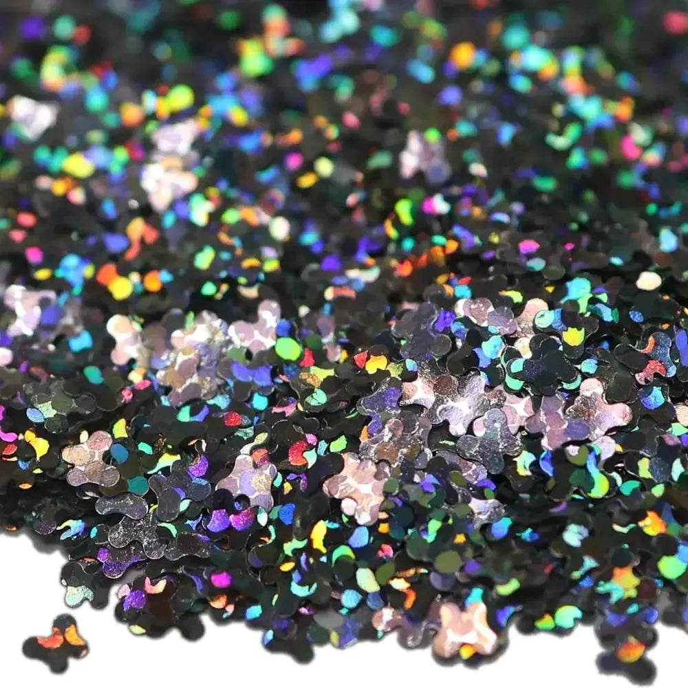 Close-up of black holographic glitter flakes in butterfly shapes with pink pieces