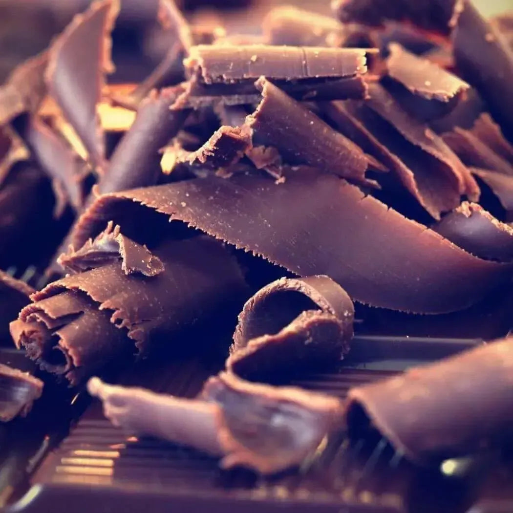 Curled dark chocolate shavings piled on a grooved surface