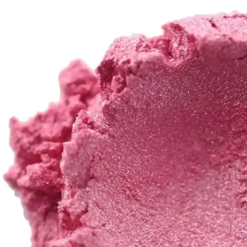 Mound of shimmering rose pink mica powder on white