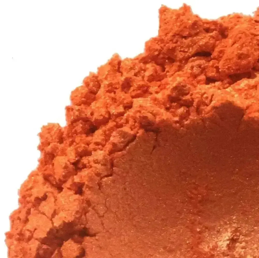 Mound of bright orange mica powder with golden shimmer