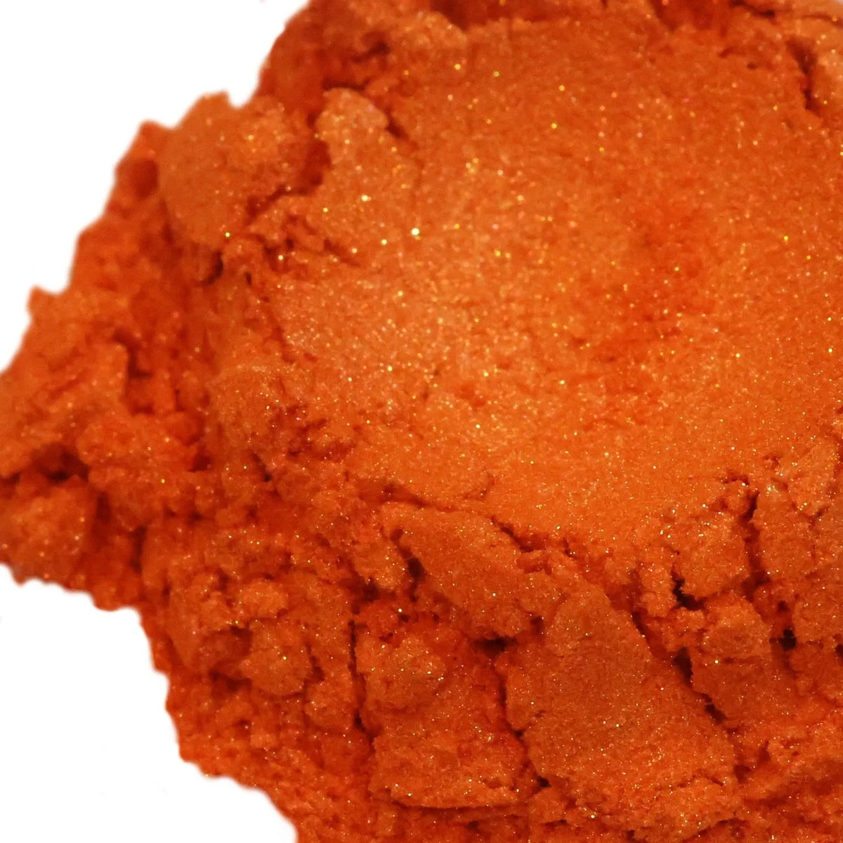 Mound of bright orange mica powder with fine golden shimmer