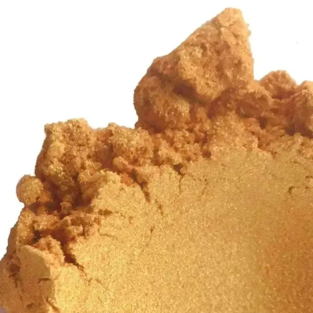 Mound of shimmering golden bronze mica powder on white