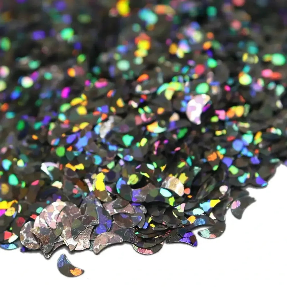 Colorful biodegradable glitter shaped like crescent moons, perfect for eco-friendly crafts and handmade projects.