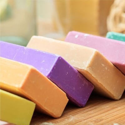 Colorful handmade soap bars stacked on a wooden surface.