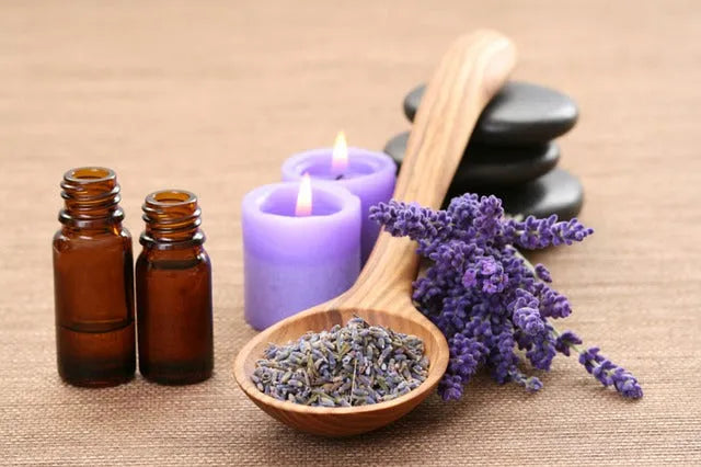 Lavender essential oils, candles, and dried flowers for fragrance blending on a natural background.