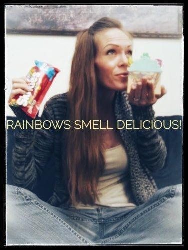 Woman smelling frosted cupcake soap, holding candy bag, Rainbows Smell Delicious
