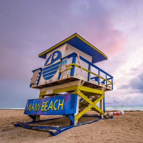 Colorful Miami Beach lifeguard tower against a cloudy sunset sky.