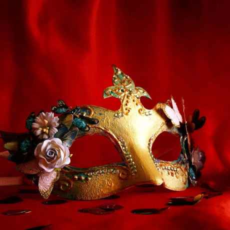 Elegant gold masquerade mask adorned with flowers and jewels on a red background