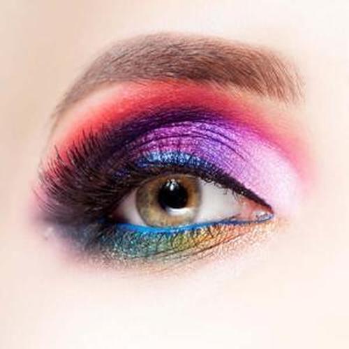 Vibrant eye makeup featuring FDA-approved colors on eyelids, showcasing bold purples, pinks, and shimmering blues.