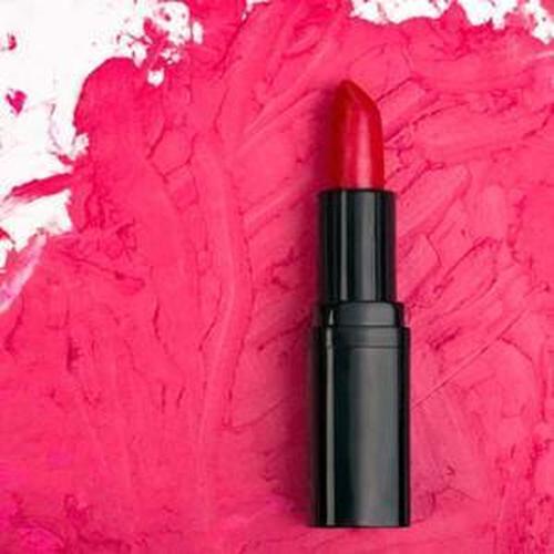 Vibrant FDA-approved red lipstick on pink background, ideal for rich color and safe application.