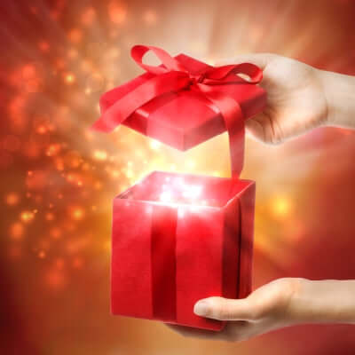 Hands Opening a Red Gift Box with Glowing Light Inside