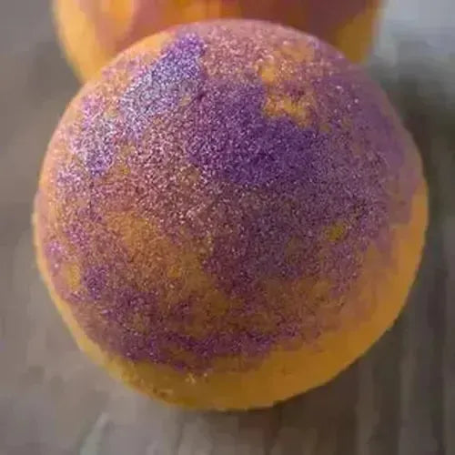 Colorful orange and purple bath bomb, sparkling with vibrant skin-friendly shades for a luxurious soak.