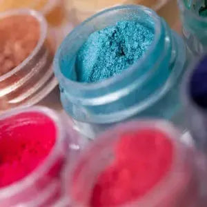 Vibrant mica powders in jars featuring blue, pink, and red shades for creative projects.