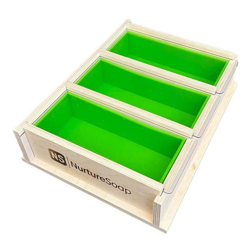 Wooden soap mold with three green silicone liners from Nurture Soap, perfect for nurturing handmade soap creations.