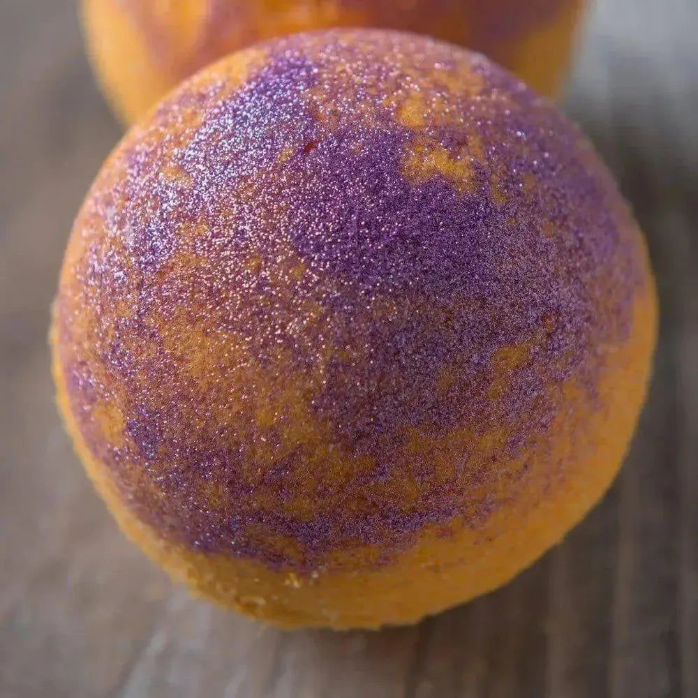 Round orange bath bomb with sparkling purple glitter in Glitters Sample Set