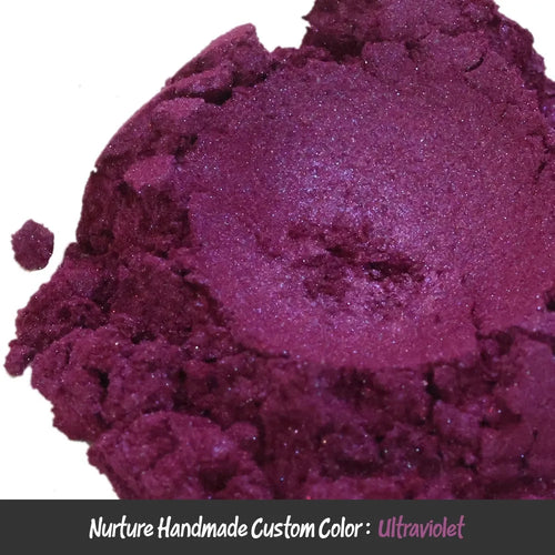 A close-up of loose, shimmery neon purple powder labeled “Ultraviolet Dark Purple Mica” rests atop a black and gray border.