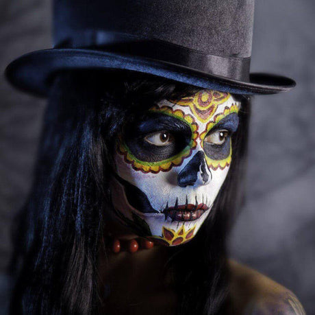 Person with Dia de los Muertos face paint wearing a black top hat and red beaded necklace