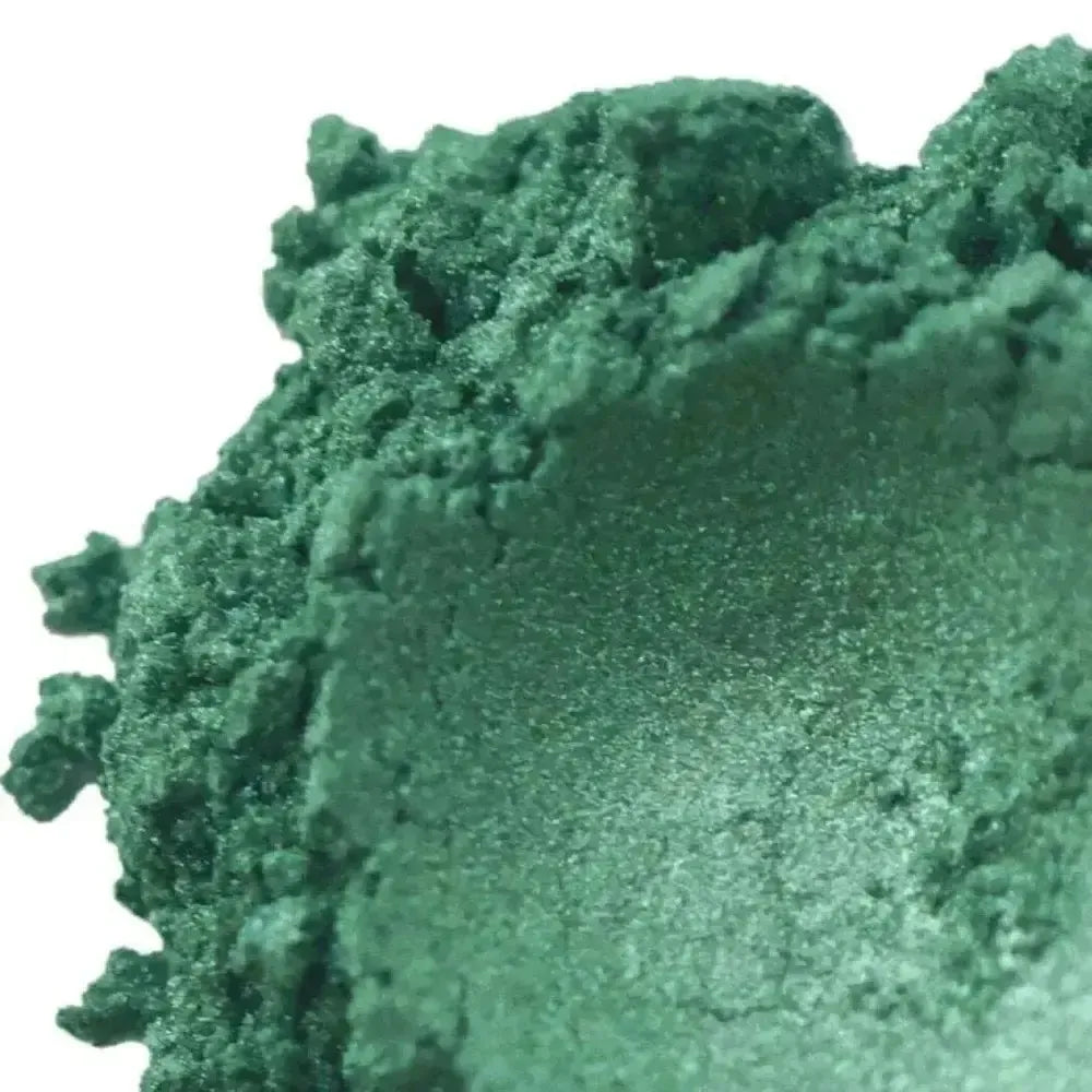 Alpine Green Mica is a shimmery green powder with smooth centers and rough edges, reminiscent of evergreen forests—ideal for nature-inspired crafting.