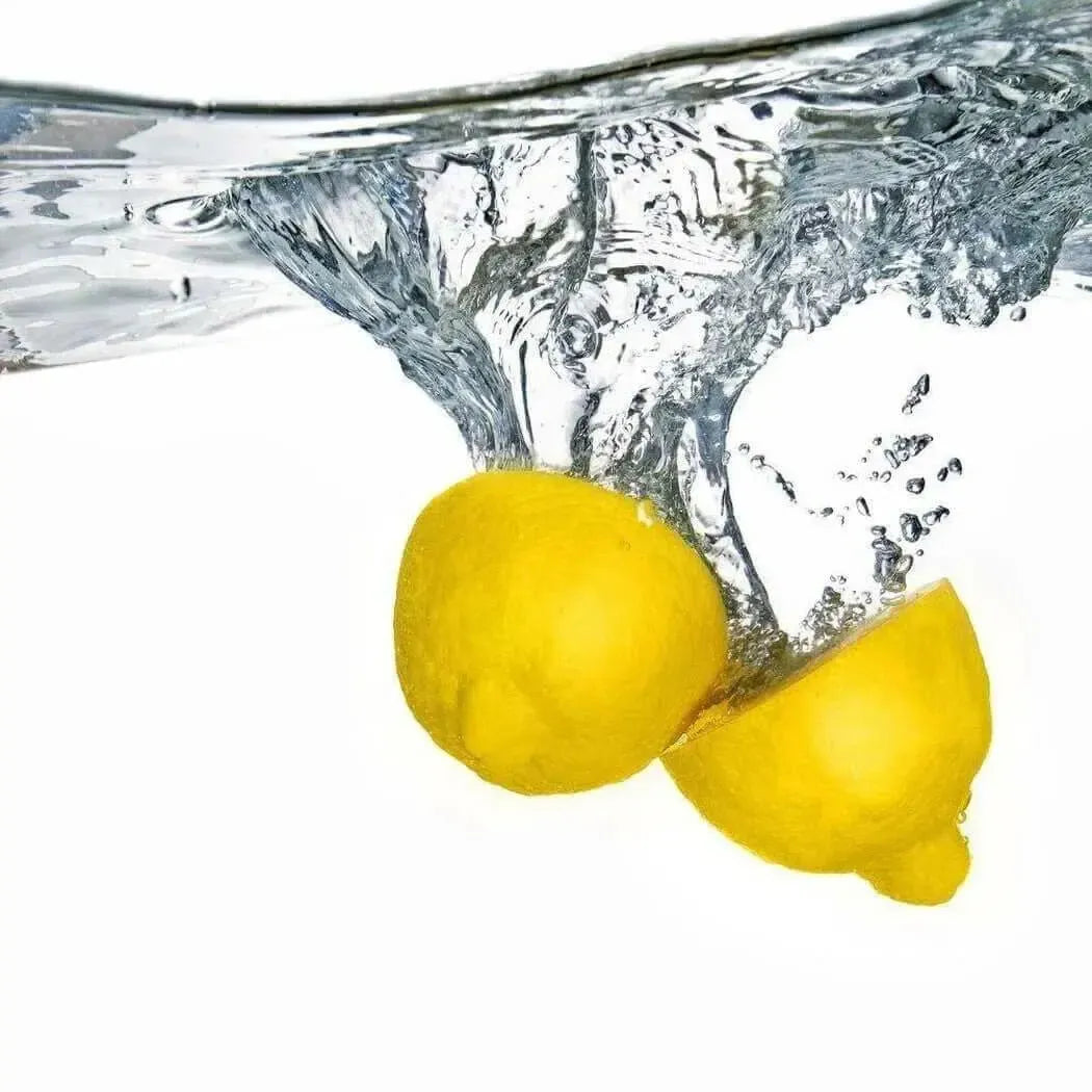 Two yellow lemons splash into clear water for Awaken Fragrance Blend