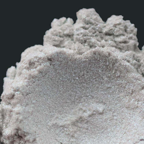 Close-up of a gray powdery substance with a textured surface, symbolizing Nurture Handmade natural products.