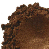 Close-up of crumbled, rich brown eye shadow powder texture, highlighting Nurture Handmade makeup.