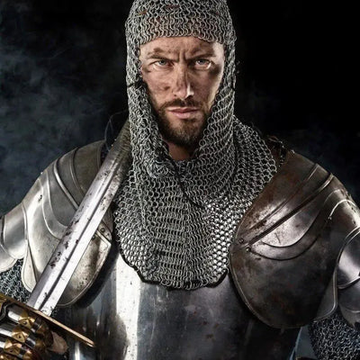 Bearded man in chainmail coif and steel plate armour holding sword