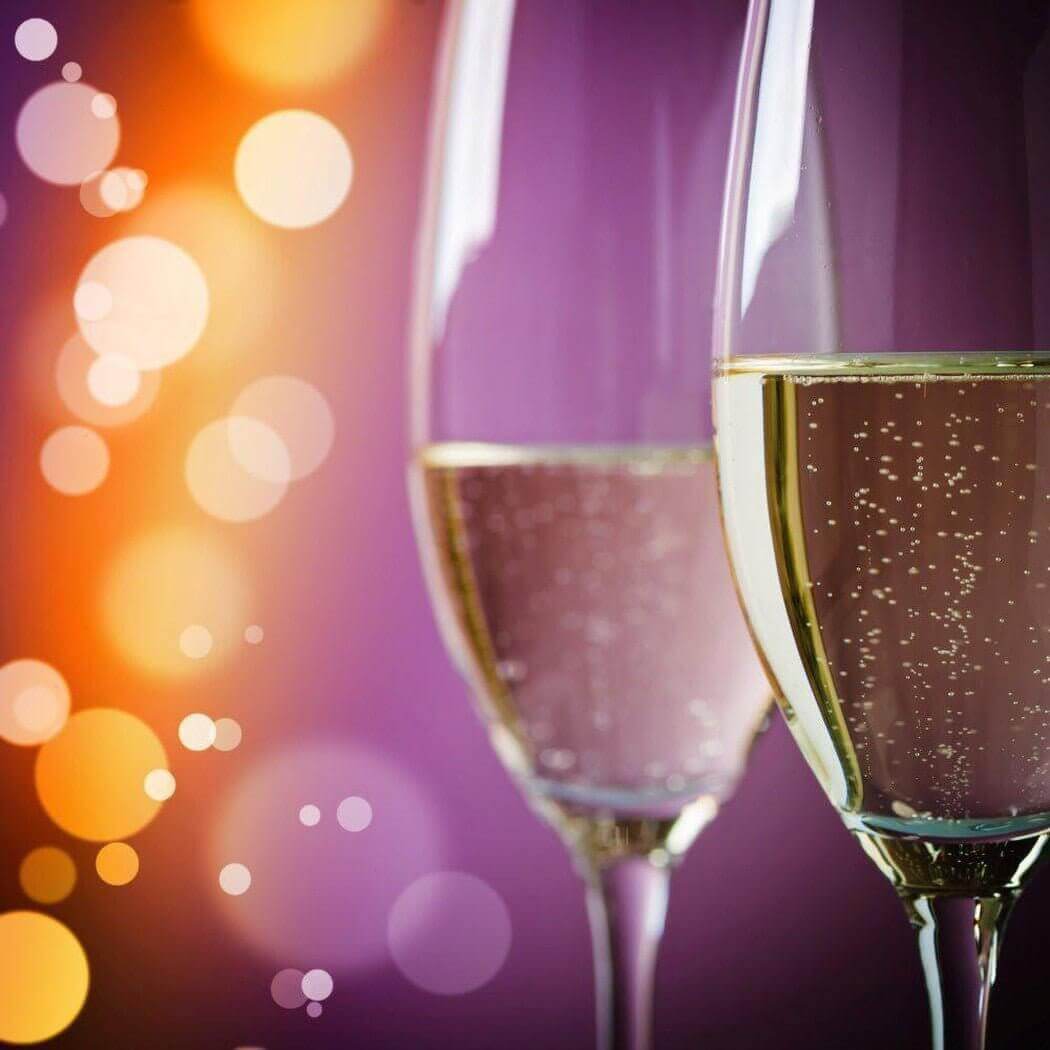 Two champagne glasses with bubbles against a colorful bokeh background, symbolizing celebration and special moments.