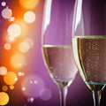 Two elegant champagne flutes with golden bubbly liquid in Champagne Fragrance Blend
