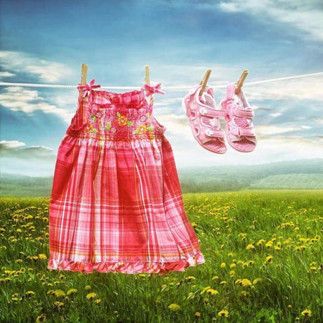 Red plaid dress and pink shoes on clothesline in a sunny meadow filled with wildflowers, Nurture Handmade products.