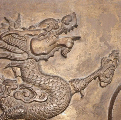 Intricate carving of a dragon surrounded by swirling clouds, showcasing ancient artistry and mystical themes.