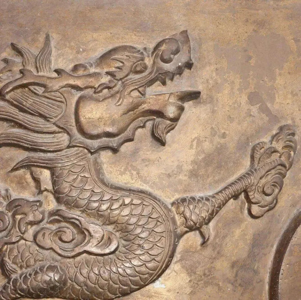 Bronze dragon relief with scales and mane on weathered metal for Dragon’s Blood Fragrance Blend