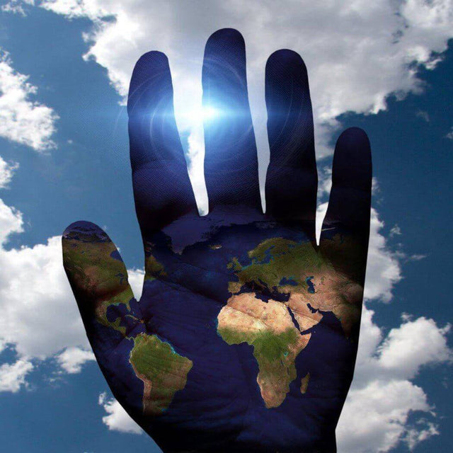 A hand with a world map overlay, reaching towards the sky with sun rays and clouds in the background, symbolizing global connection.