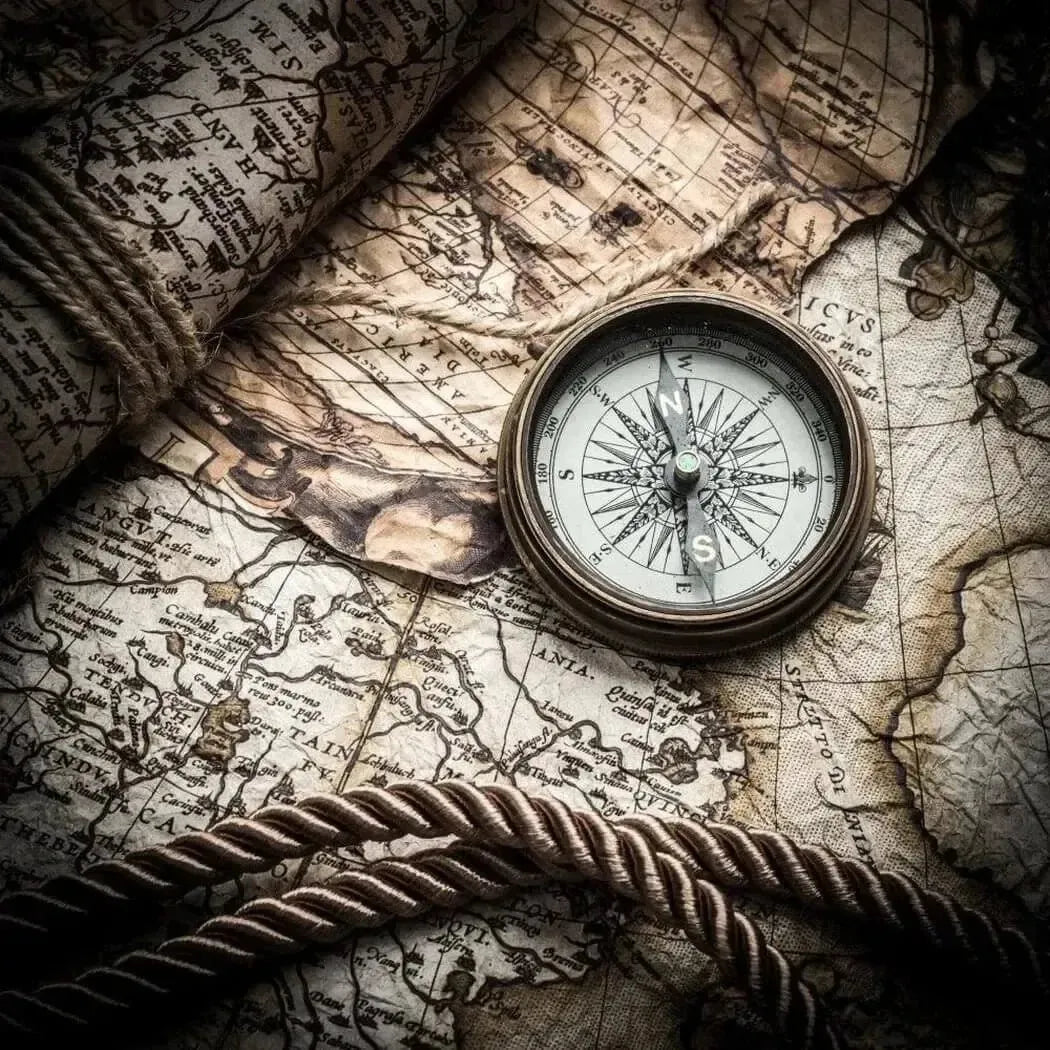 Vintage brass compass on aged parchment map for East to West fragrance blend
