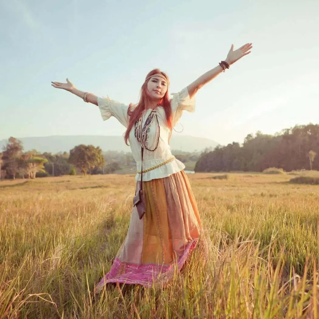 Barefoot woman in flowing multi-toned skirt and white blouse in golden grass, Free Spirit Fragrance Blend