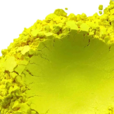 Mound of bright chartreuse yellow pigment powder on white
