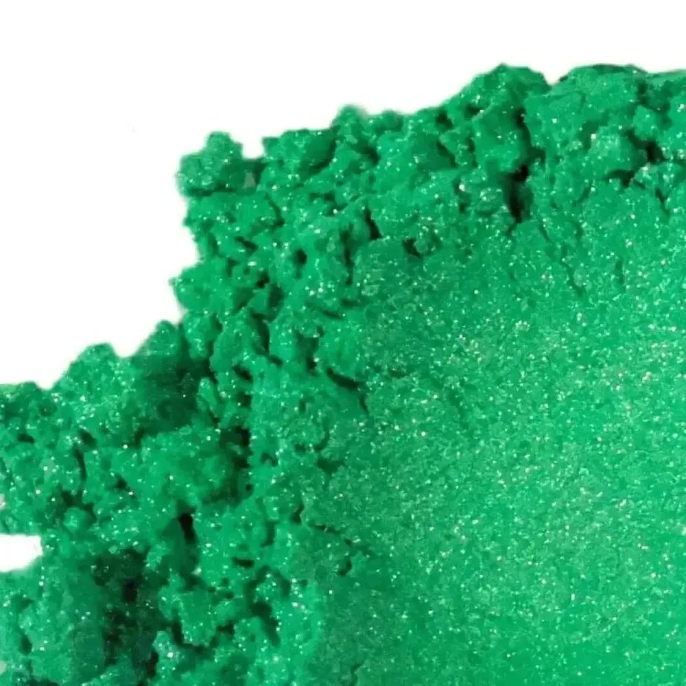 Green Vibrance Mica gives kinetic sand a vivid green color. On the left, the sand appears rough and crumbly; on the right, it’s smooth and pressed, showcasing its granular texture and eye-catching hue.