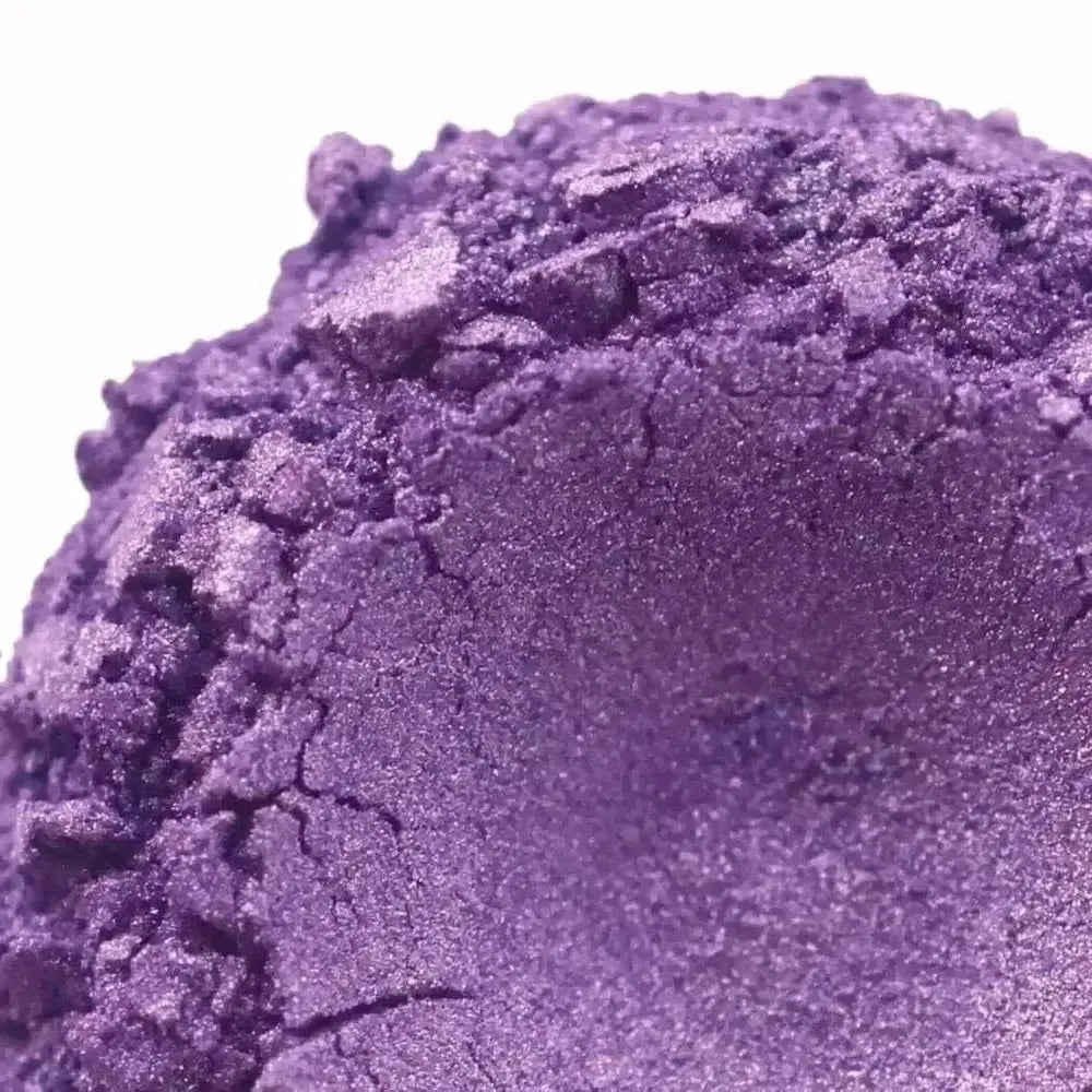 Close-up of Iris Purple Mica, a shimmery purple eyeshadow, crushed into a textured pile against a white background.