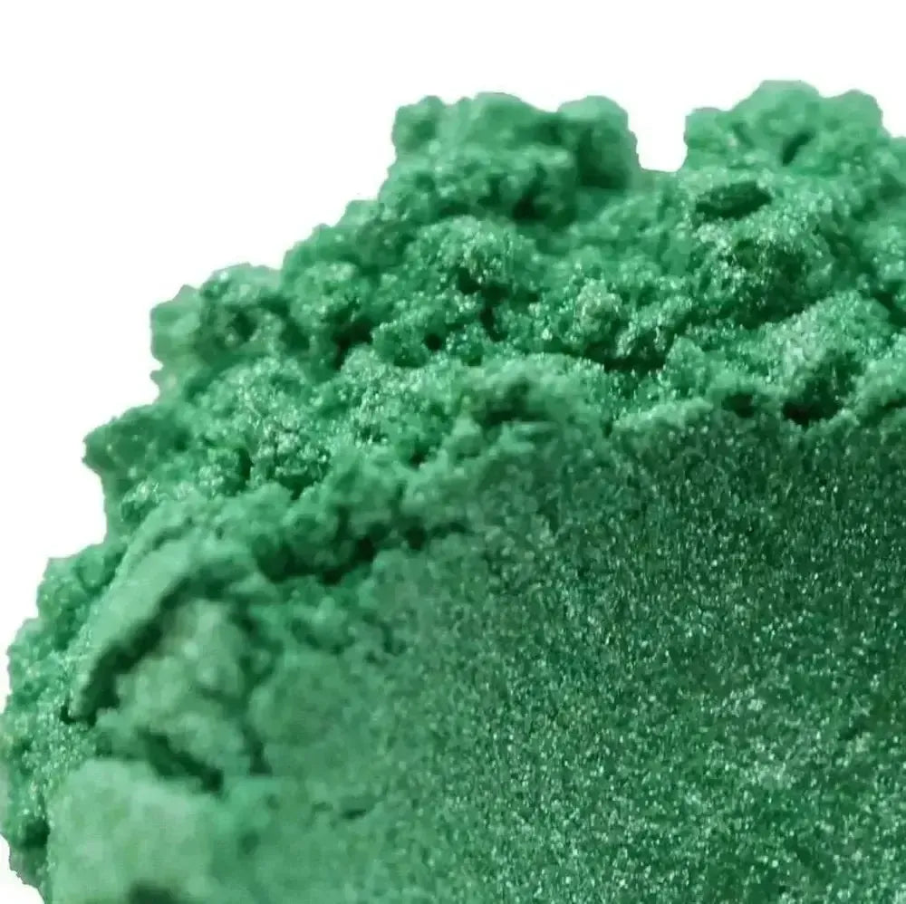 Close-up of Laurel Green Mica shows its vibrant, textured powder with subtle shimmering silver flecks on a white background.