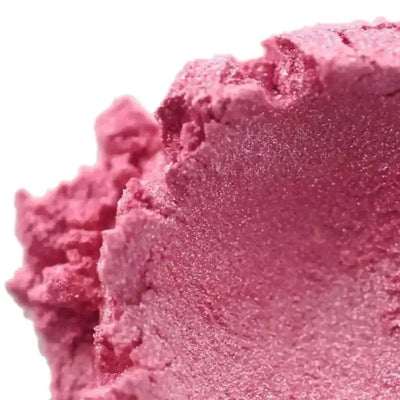 Mound of shimmering rose pink mica powder on white