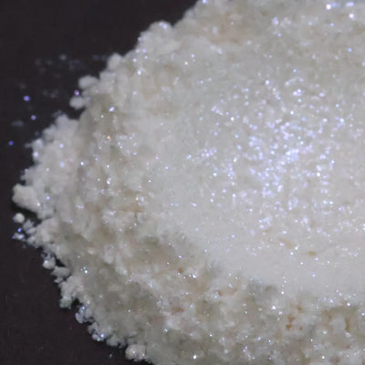 White iridescent glitter powder heaped on dark background