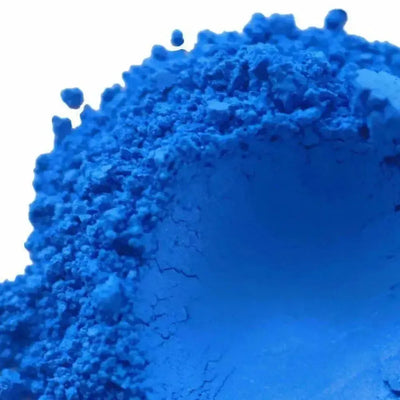 Mound of bright cerulean blue mica powder on white