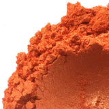 Close-up of crushed orange powder, highlighting its texture and vibrant color. Nurture Handmade cosmetics product.