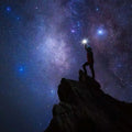 Silhouetted hiker atop rocky peak under Milky Way stars for Milky Way Fragrance Blend