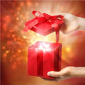 Nurture Handmade Gift Card: vibrant red box with ribbon bow held open by hands on golden background