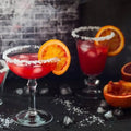 Vibrant red Orange Cognac Fragrance Blend cocktail in sugared glass with blood orange slice