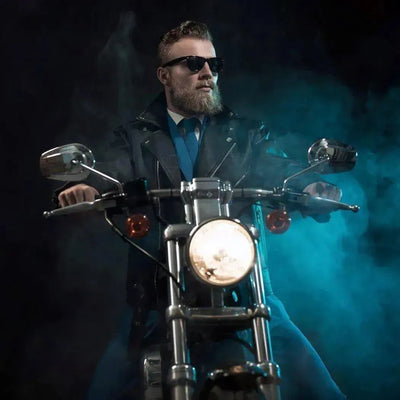Bearded man in sunglasses on a motorcycle amid blue smoke