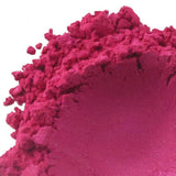 Bright pink powdered pigment in a heap, illustrating the vibrant color and fine texture used in handmade products. Nurture Handmade.