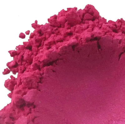 Crumbly matte magenta mica powder heaped on white background