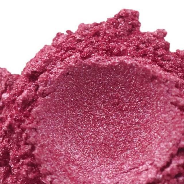 Close-up of vibrant pink shimmery crushed eyeshadow by Nurture Handmade, showcasing its textured and glittery appearance.