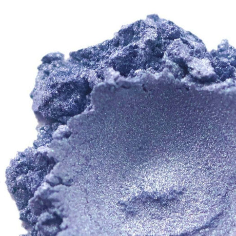 Nurture Handmade shimmering blue pigment powder close-up on a white background.